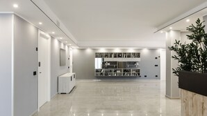 A spacious, modern hallway with a polished floor, a built-in bookshelf, and a reception desk. - Villa Olivieri B&B - Wellness House  (Viterbo)