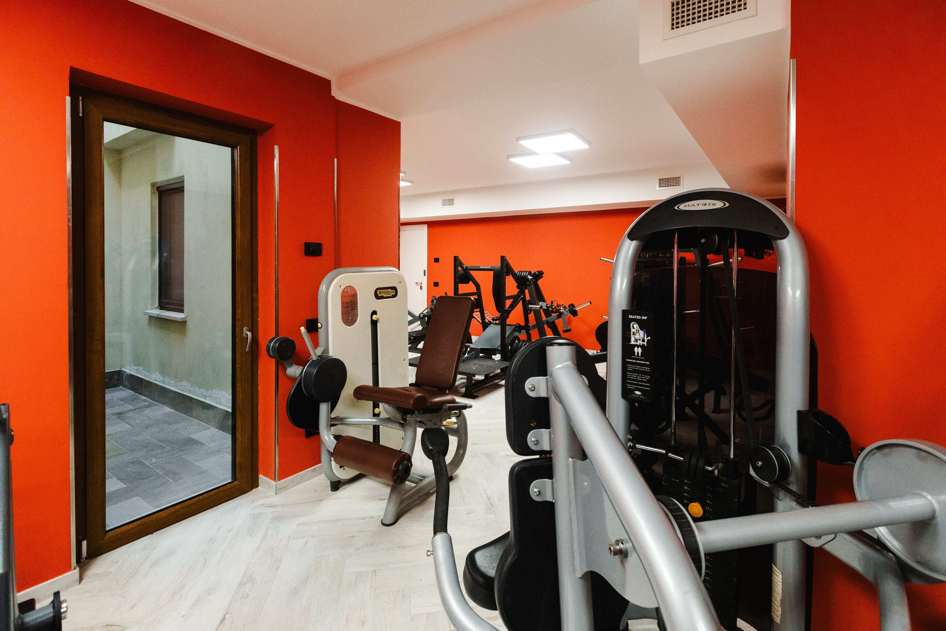Un gimnasio con equipo de ejercicio y un espejo.