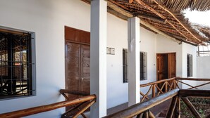 Une balustrade en bois, une porte en bois et une fenêtre avec une grille en métal.
