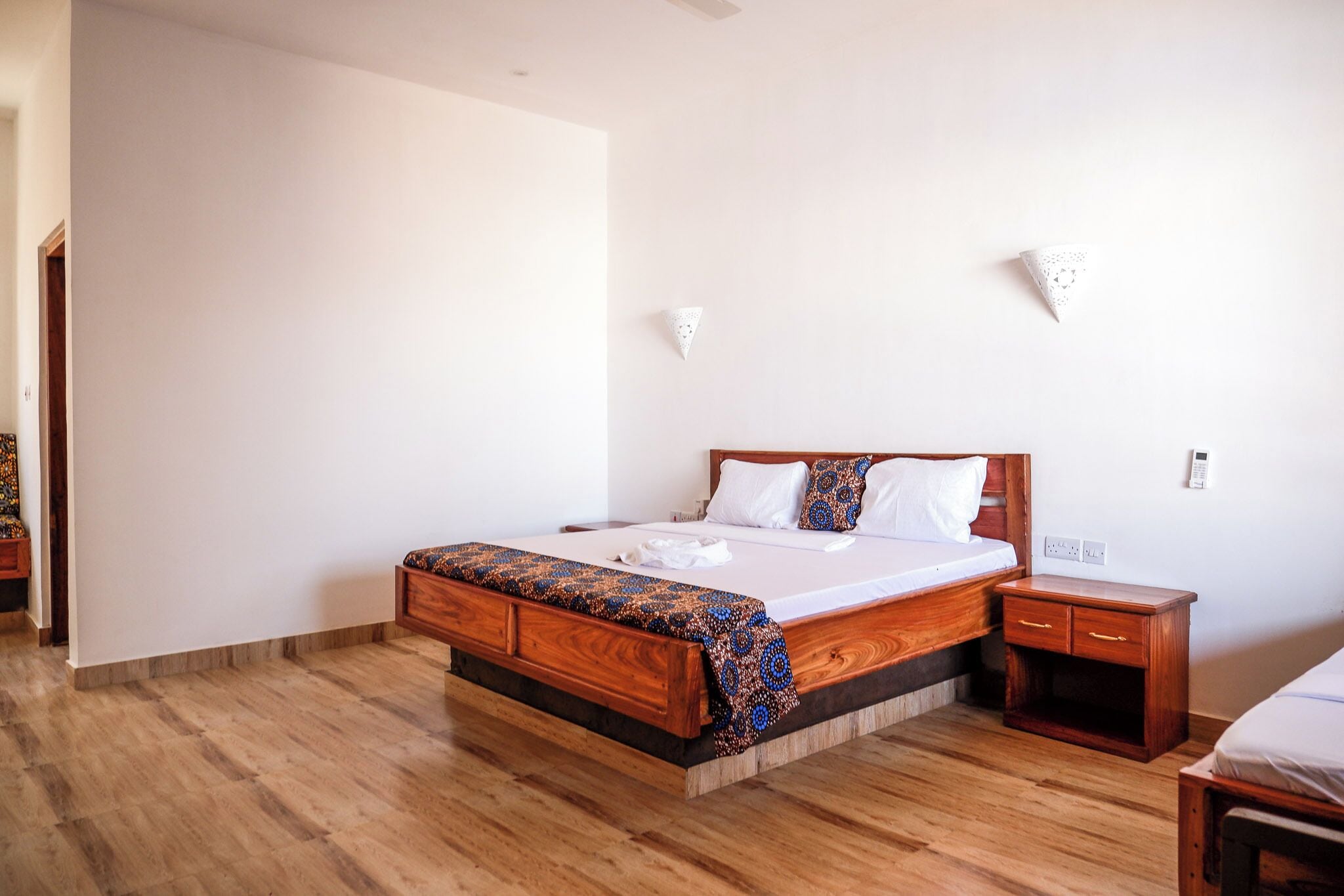 Un dormitorio con una cama de madera, una mesita de noche y una mesita auxiliar.