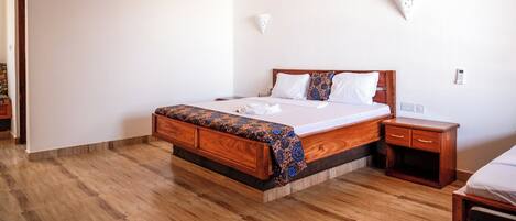 Un dormitorio con una cama de madera, una mesita de noche y una mesita auxiliar.