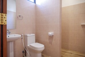 Un baño con lavamanos, inodoro y toallero.