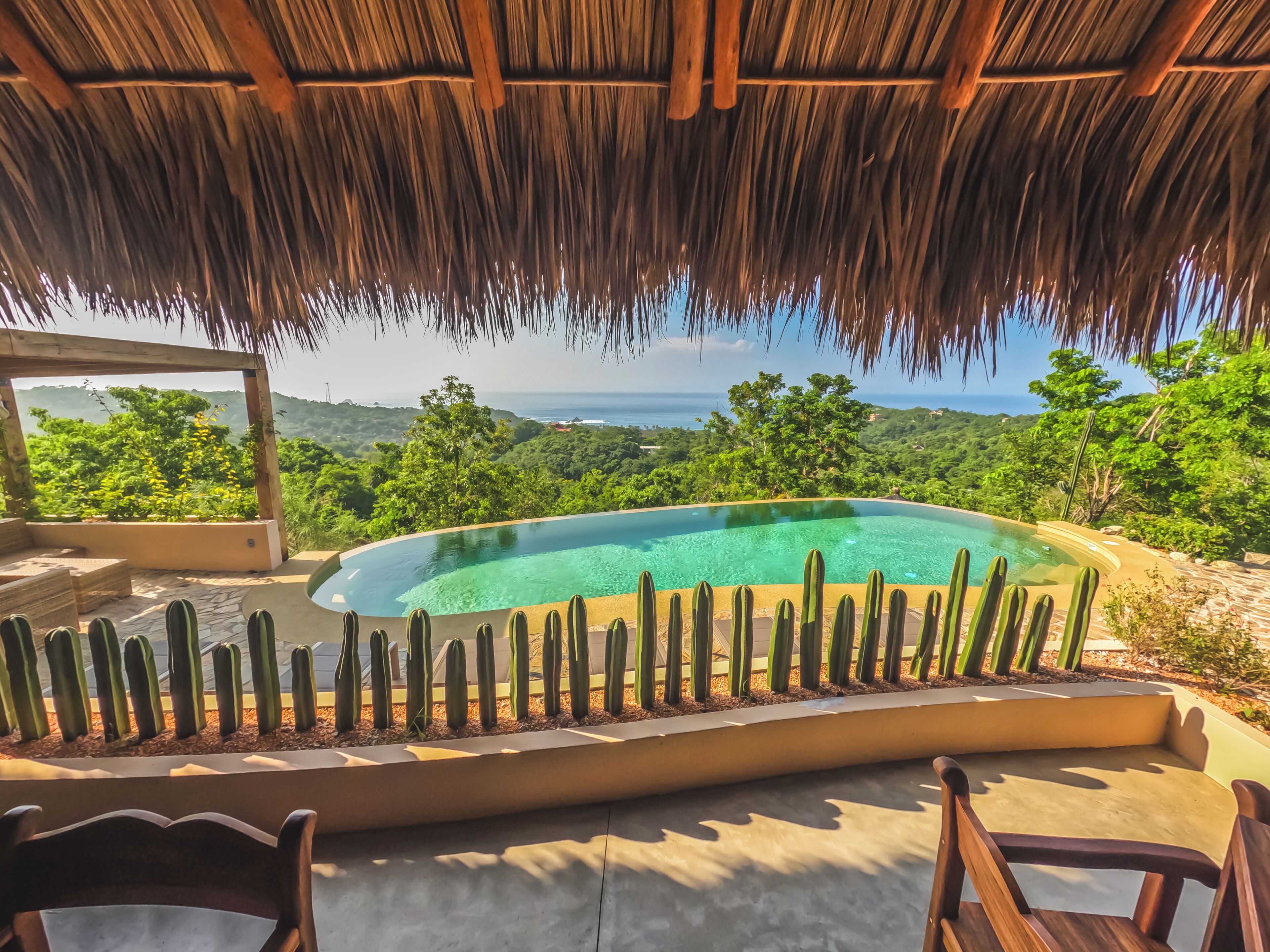 Alberca al aire libre, sombrillas en la alberca y camastros 