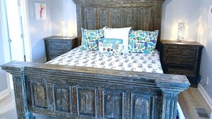 A rustic wooden bed with a patterned bedspread and matching pillows, flanked by two nightstands with decorative items. - 11 Drift - 2BR $700+ in freebies incl golf, pool (Miramar Beach)
