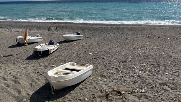 A beach with several small boats and a beach umbrella. - Macallè House Letojanni - Taormina (Letojanni)