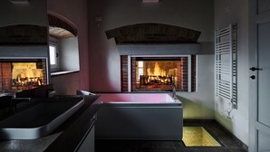 A modern bathroom with a large bathtub, a shower area, and a fireplace. - The Crusher (whirlpool) (Rivalto)