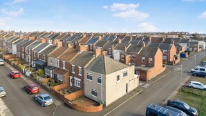 A row of terraced houses with a street in front.