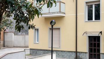 A building with a balcony, a door, and a window.