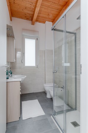 Een douche, een haardroger, handdoeken, toiletpapier