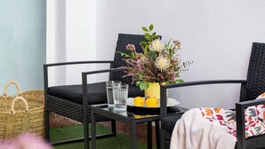 A small outdoor seating area with a table, chairs, and a potted plant. - Bon voyage home, private patio (Sevilla)