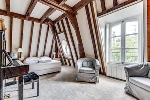 Cozy attic bedroom with a comfortable bed, piano, and a view of the outdoors.