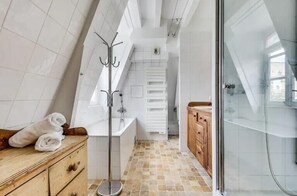 Enjoy a clean and minimalist bathroom with a glass shower enclosure and a convenient storage cabinet.
