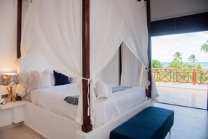 A four-poster bed with a canopy, white bedding, and a view of the ocean through a balcony. - Villa Bahia Rincon: A Taste of Paradise (Samaná Province)