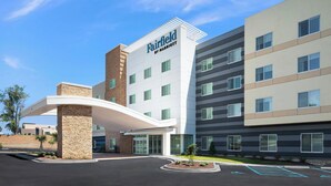 Un hotel Fairfield by Marriott dal design moderno, con un ingresso ben visibile, una galleria coperta e un'area di parcheggio.