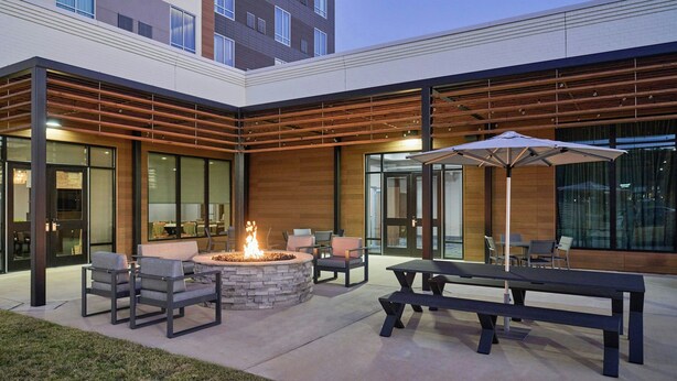 An outdoor patio with a fire pit, seating, and a large umbrella. - Residence Inn by Marriott Huntsville - Madison (Madison)