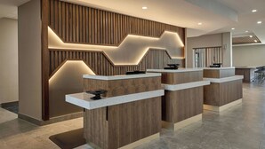 A reception area with a modern design, featuring wooden paneling and a geometric light fixture. - Courtyard by Marriott Huntsville-Madison (Madison)
