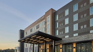 A modern hotel with a covered entrance, multiple floors, and large windows. - Courtyard by Marriott Huntsville-Madison (Madison)