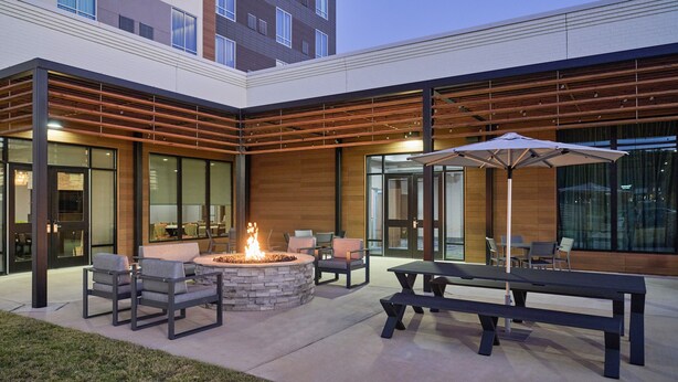 An outdoor patio area with a fire pit, seating, and a table. - Courtyard by Marriott Huntsville-Madison (Madison)