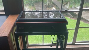 Een keukenhoek met een aanrecht en een raam met uitzicht op een tuin.