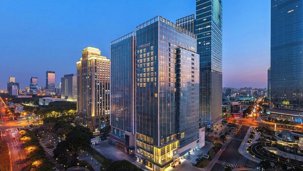 A high-rise building with a modern glass facade, surrounded by other tall buildings and a busy urban street at dusk. - Fairfield By Marriott Suzhou Jinji Lake (Suzhou)