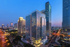 A high-rise building with a modern glass facade, surrounded by other tall buildings and a busy urban street at dusk. - Fairfield By Marriott Suzhou Jinji Lake (Suzhou)