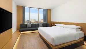 A modern hotel room with a large bed, a sofa, a TV, and a city view. - Fairfield By Marriott Suzhou Jinji Lake (Suzhou)