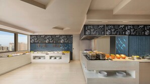 A modern kitchen with a buffet setup, large windows, and city views. - Fairfield By Marriott Suzhou Jinji Lake (Suzhou)