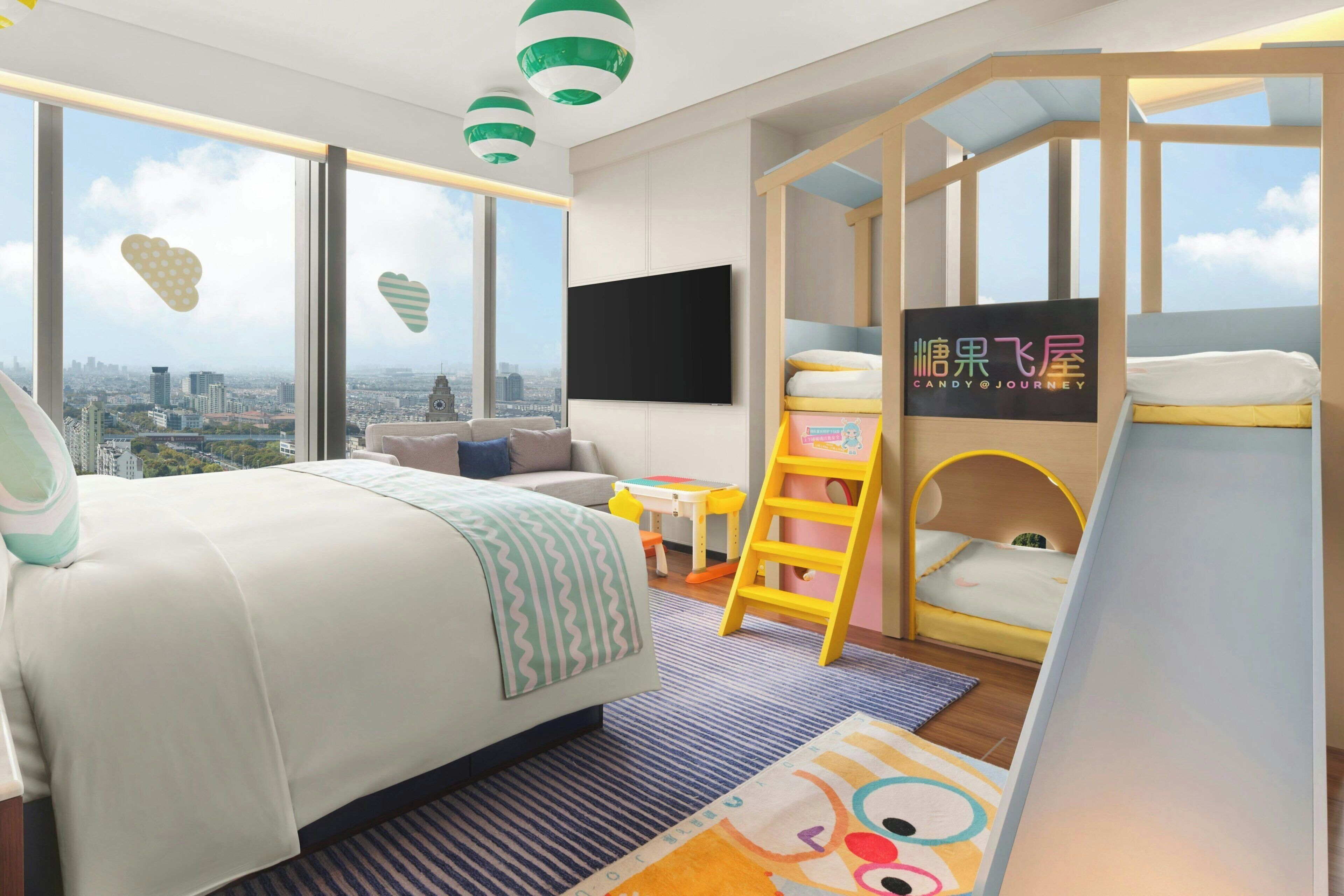 Quarto moderno com cama grande, escrivaninha, cadeira, escada e beliche.