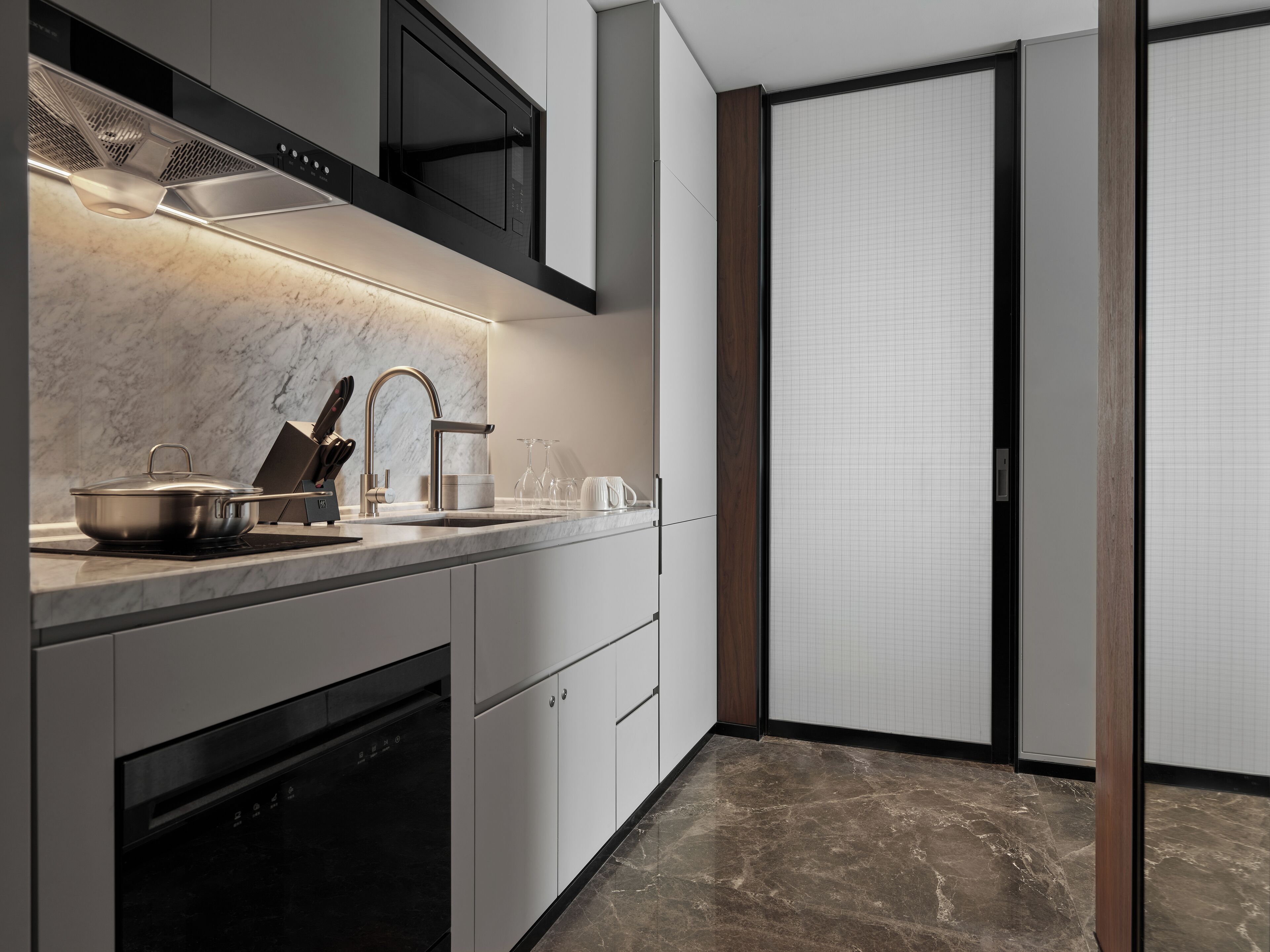 A modern kitchen with a built-in stove, microwave, and oven.