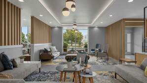 A modern interior with a sofa set, a coffee table, and a dining area. - Towneplace Suites By Marriott Nampa (Nampa)