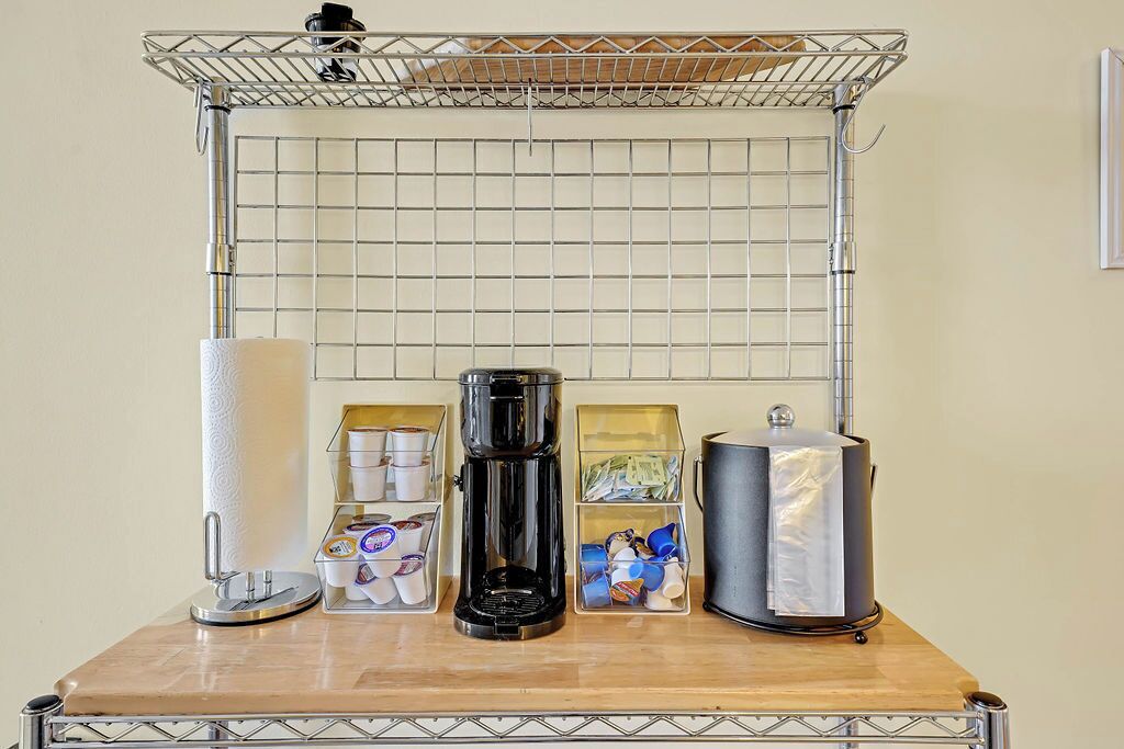 A kitchen counter with a coffee maker, a kettle, and storage containers.