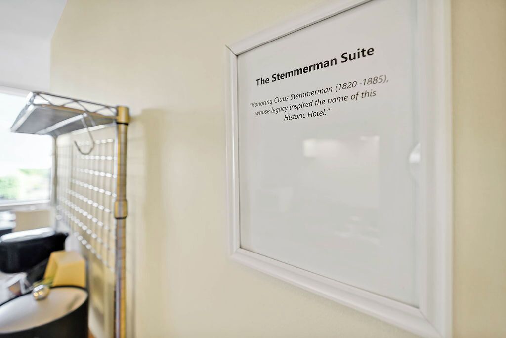 A framed sign in a hotel room indicating the room is part of the Stemmerman Suite, named after a historical figure.