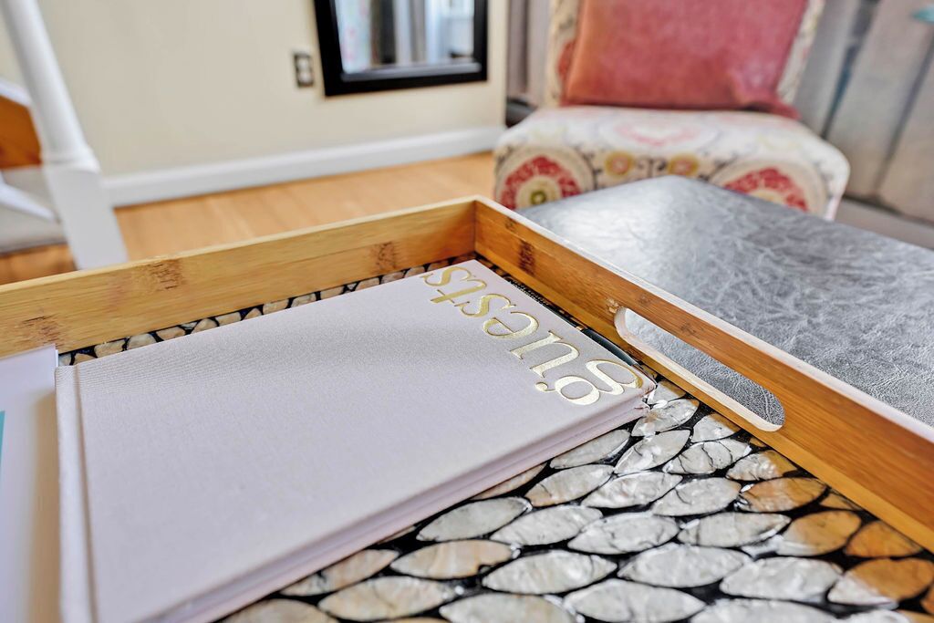 A wooden tray with a notebook and a gray surface on a patterned floor.