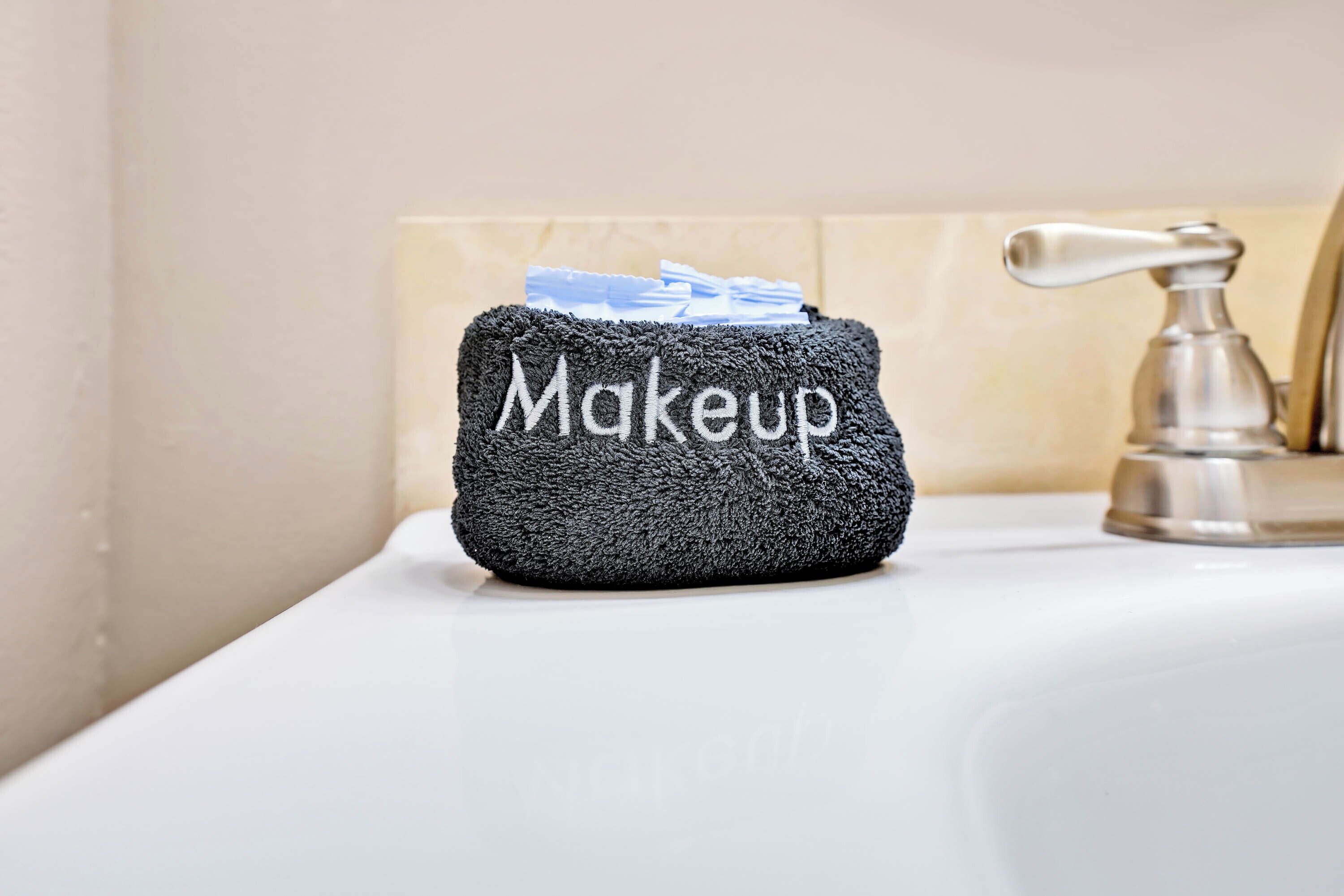 Un neceser negro con la palabra "Makeup" sobre un lavamanos de baño.