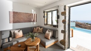 A modern living room with a grey sectional sofa, a wooden coffee table, and a large abstract painting on the wall.