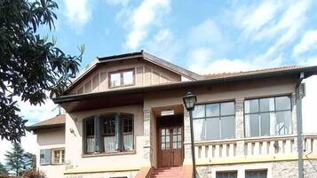 Stroll up the paved pathway to the entrance of this charming two-story building, surrounded by a beautifully maintained lawn and lush greenery.