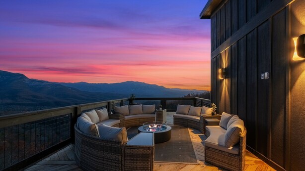 A deck with a circular seating area, a fire pit, and a view of mountains. - Stunning View, Modern Cabin in Gatlinburg, Htd Indoor Pool, Hot Tub, Game Room! (Gatlinburg)