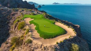 A coastal golf course with a clear view of the ocean and distant mountains. - Villa Del Palmar in Loreto, Luxurious Relaxation & Adventure, Resort Life (Loreto , B.C.S)