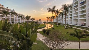 A resort with multiple-story buildings, a central water feature, and palm trees. - Luxury Beachfront Apartment with Infinity Swimming Pools in Nuevo Vallarta (Nuevo Vallarta)