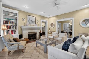 A living room with a fireplace, bookshelves, a coffee table, and a sofa.