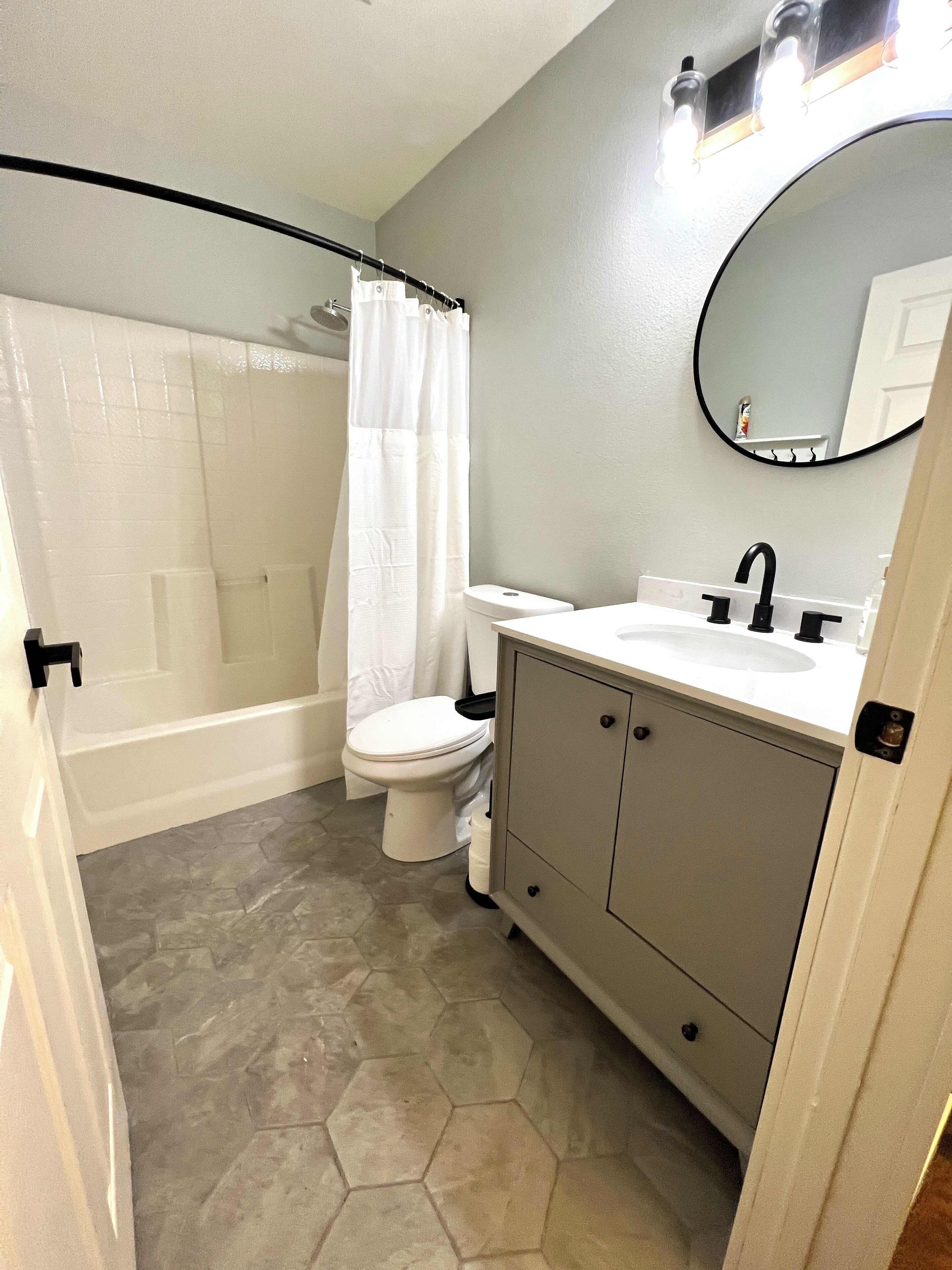 Ein Badezimmer mit Dusche, Toilette, Waschbecken und Ablagefläche.