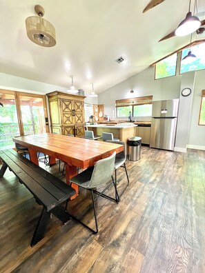 A spacious kitchen with a wooden dining table, built-in cabinets, and a stainless steel refrigerator. - Zen Zion (Glendale)