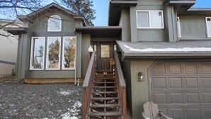 A residential house with a front entrance, a staircase leading to the door, a garage, and a driveway. - Poolside Getaway with Spacious Outdoor Living & 6 Cozy Beds!! (Spokane)