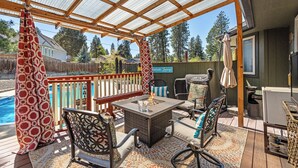 A covered patio with a pool, outdoor furniture, and a grill area. - Poolside Getaway with Spacious Outdoor Living & 6 Cozy Beds!! (Spokane)