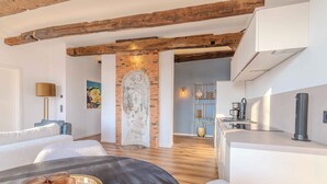 Eine moderne Küche mit Backsteinwand, Holzbalken und einer eleganten Arbeitsplatte.