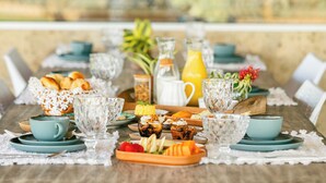 A breakfast table set with various dishes, drinks, and a fruit bowl. - Casa Mandala Corumbau (Corumbau)