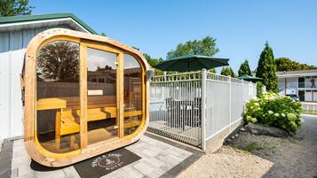 A wooden structure with glass doors, a white fence, and a sign for 'Spruce & Shore Motel'.