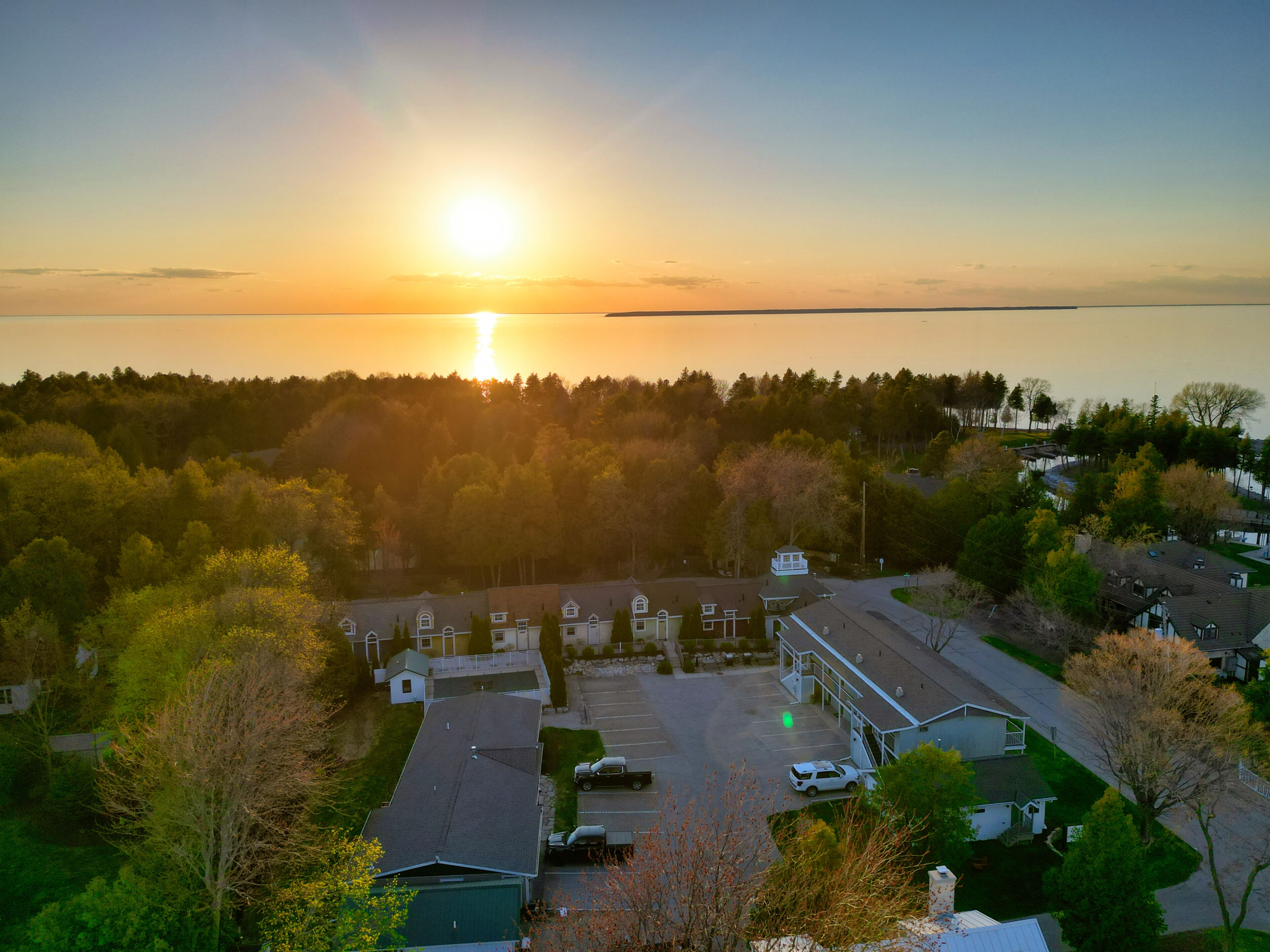 Et boligområde med parkeringsplads, huse og et vandareal i baggrunden.