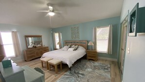 Ein Schlafzimmer mit einem Bett, Nachttischen, einem Schreibtisch und einem Stuhl.