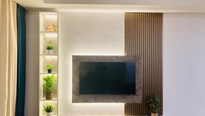 A modern living room with a flat-screen TV mounted on a wall, surrounded by shelves with plants and decorative items. - Monaara Leisure colombo 03 (Colombo)